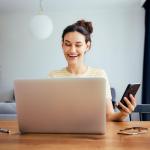 Une jeune femme valide son virement direct via itsme sur son smartphone