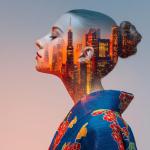 Double exposition montrant une personne de profil portant un kimono bleu traditionnel avec des motifs floraux rouges et jaunes, fusionnée avec une ligne d’horizon urbaine colorée au coucher du soleil apparaissant dans le contour de la silhouette.