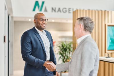 Adviseur begroet cliënt in een Nagelmackers kantoor