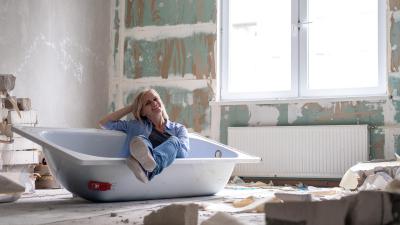 Woman sitting in a broken out bathtub