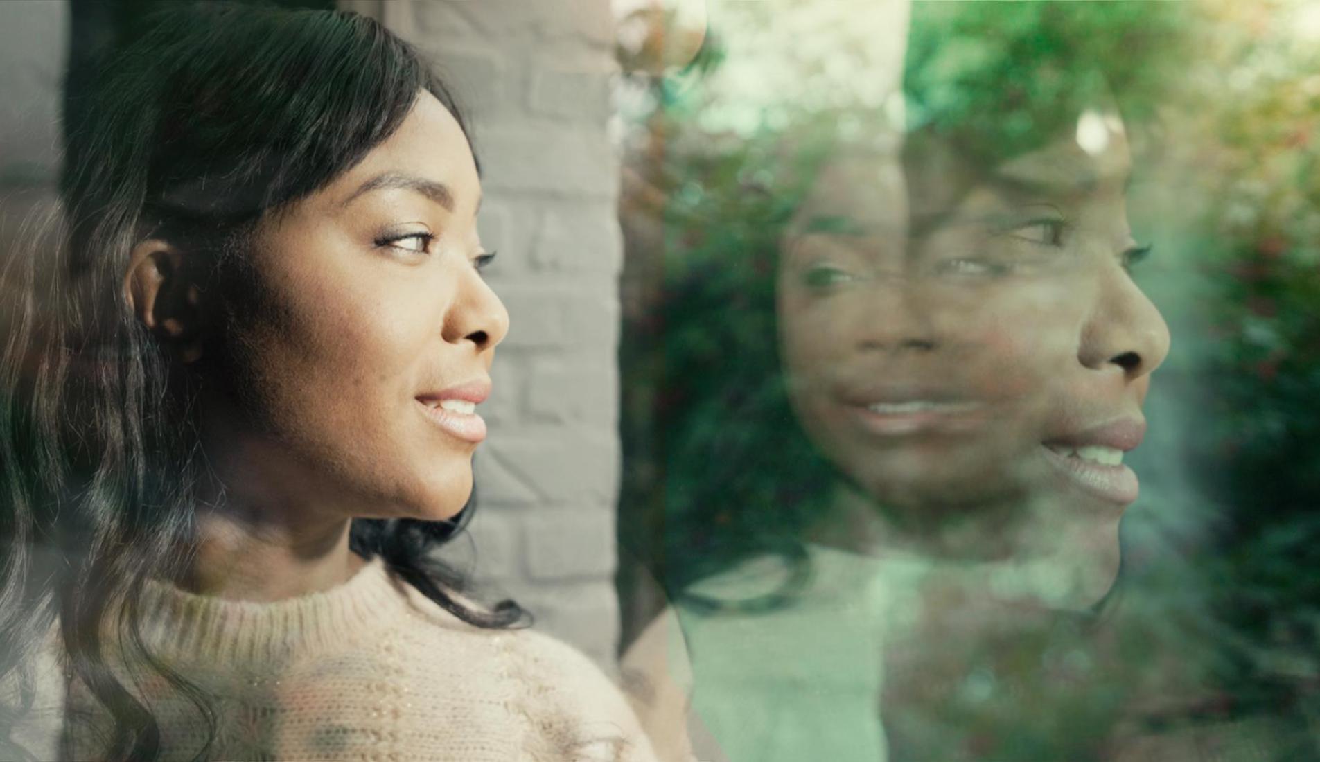 Woman looking outside through window